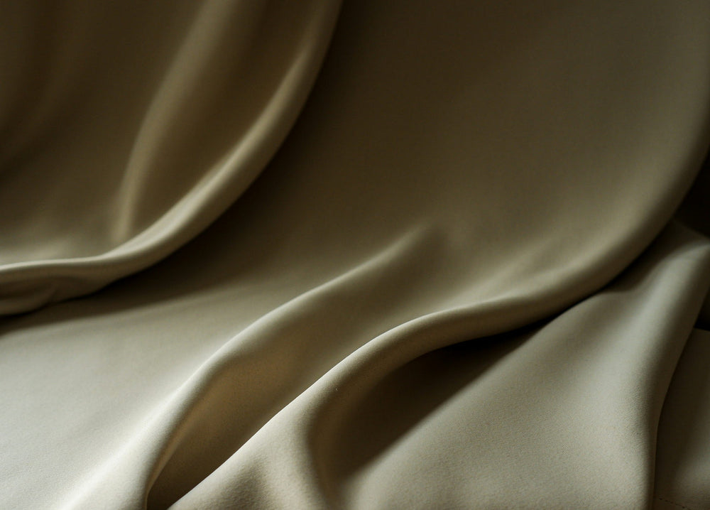 Soft directional light across folded beige fabric.